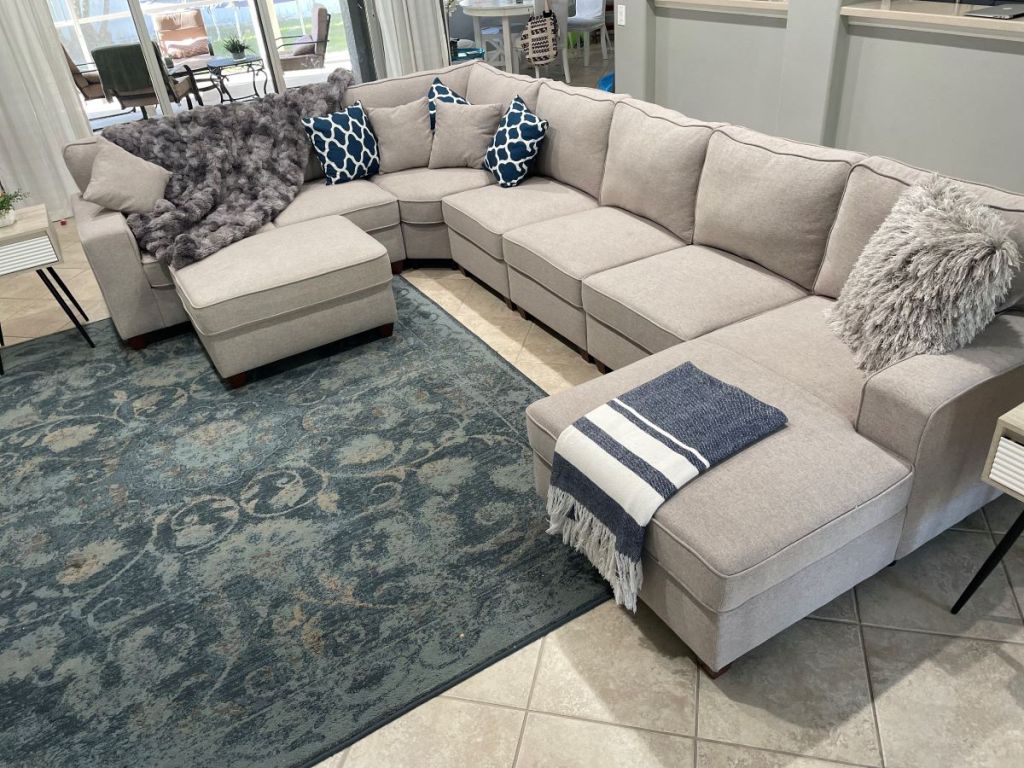 Large sectional couch with pillows and blankets on it