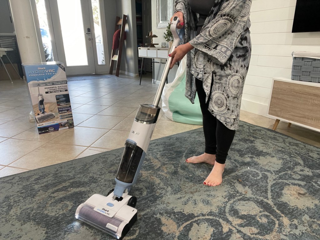 Woman using a Shark Hydrovac to clean an area rug