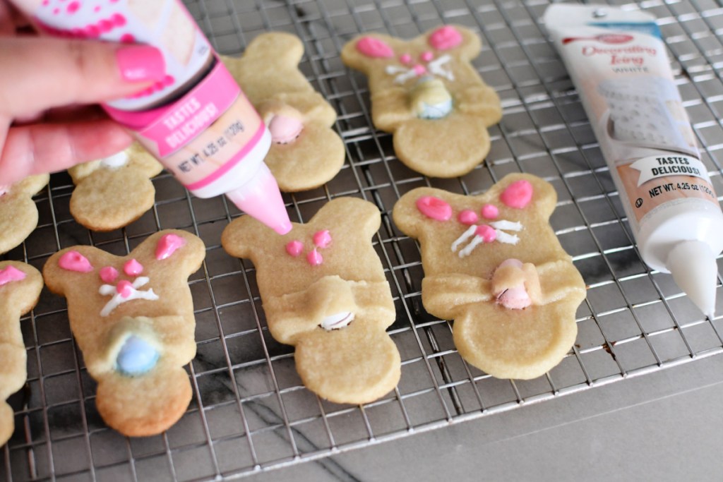 adding bunny faces using frosting to sugar cookies