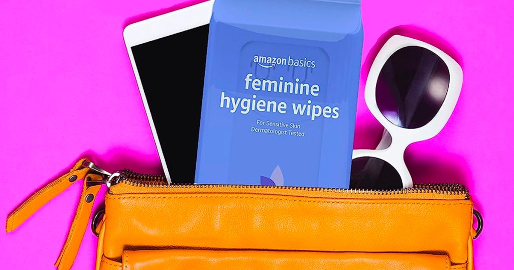 purse open with amazon basics feminine wipes, sunglasses and phone coming out of it