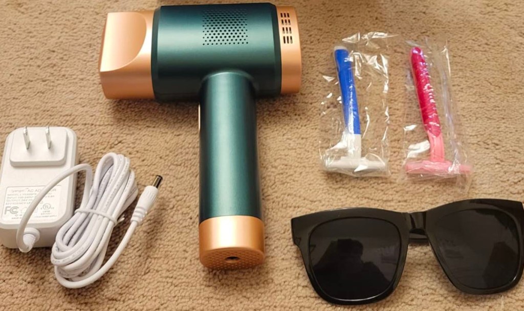 green and gold laser hair removal tool with sunglasses and razors