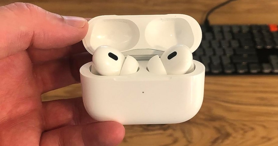 hand holding white airpod pros