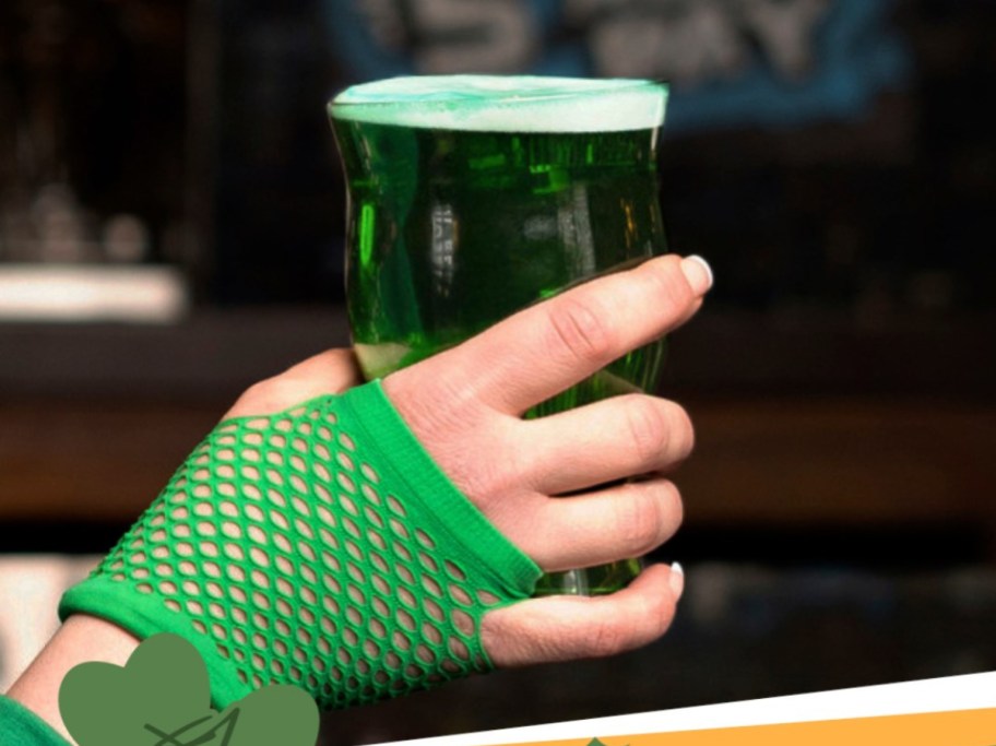 hand wearing a green glove and holding green beer