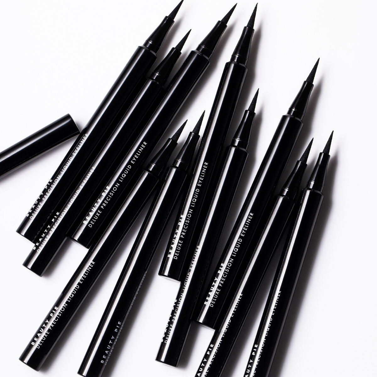 10 beauty pie eyeliners laying in a row with tops off