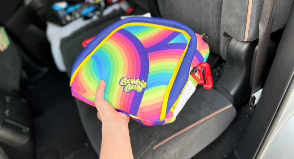 placing inflatable rainbow booster seat in car