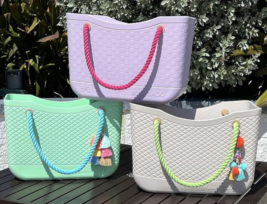 pink mint green and beige rubber bogg bag alternatives stacked on top of each other