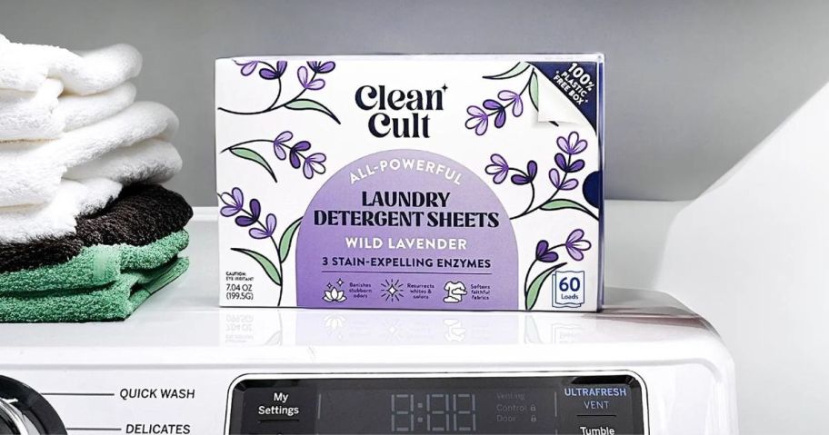 Cleancult Laundry Detergent Sheets box wild lavender on washing machine with towels stacked next to it