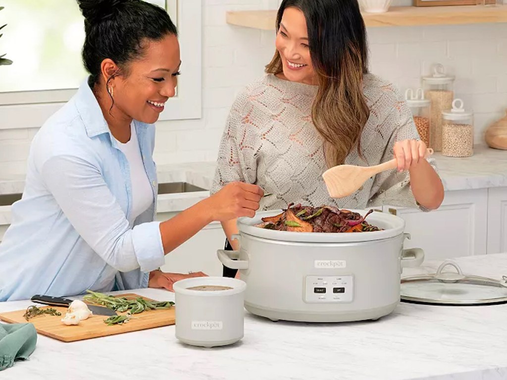 two women cooking with silver crockpot
