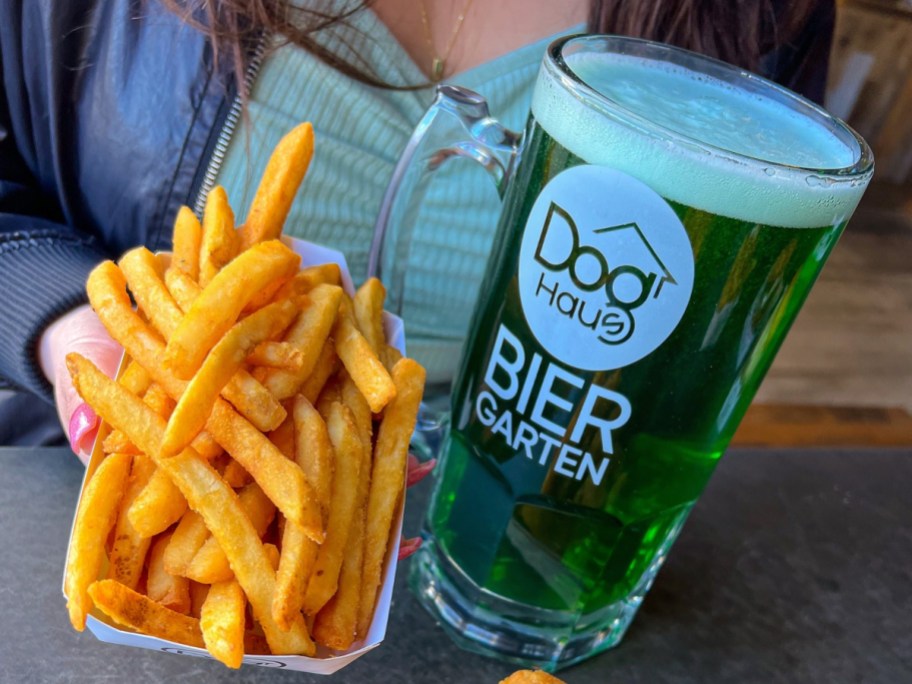 holding fries next to green beer