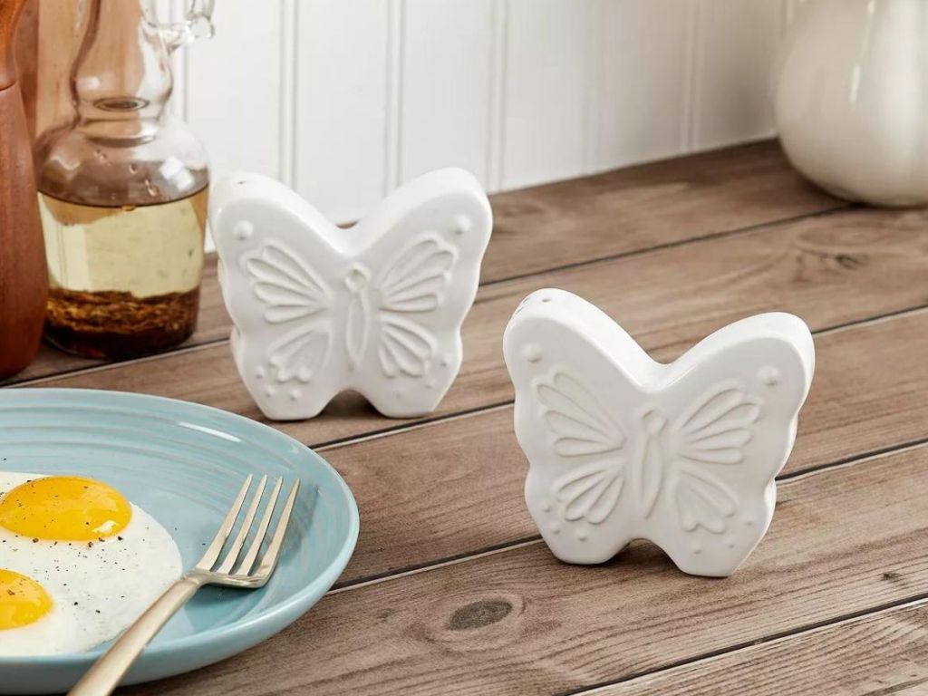 white ceramic butterfly salt and pepper shakers on wooden table