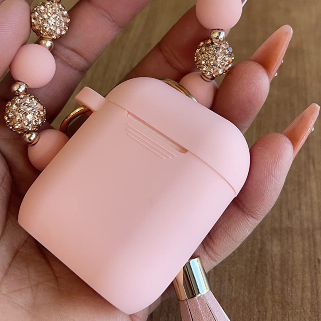 holding a pink AirPods case