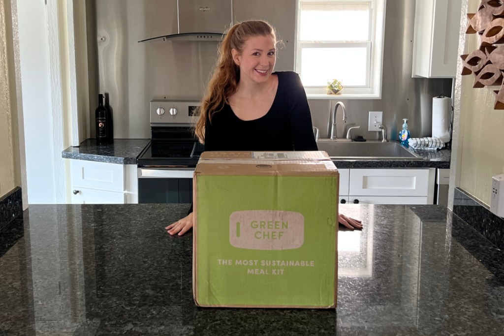 woman standing in kitchen with green chef box