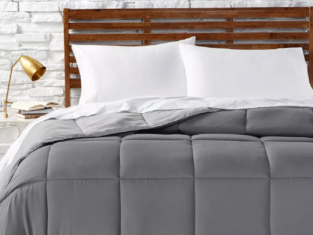 grey comforter on made bed with white pillows