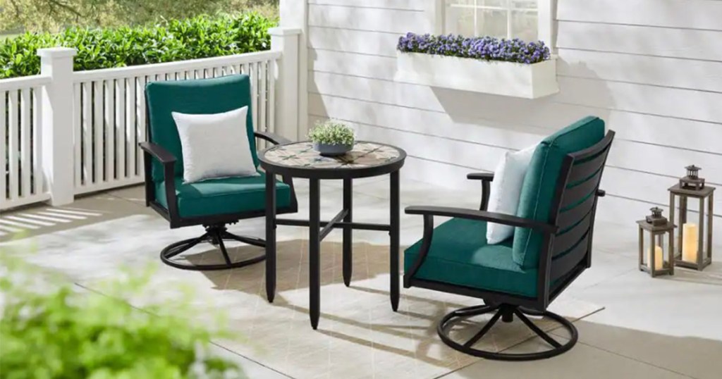 two teal rocker patio chairs on patio with glass side table