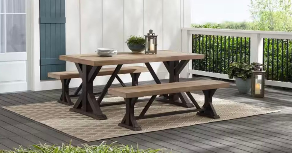 teak table with two bench seats on patio with lantern and bowl on top
