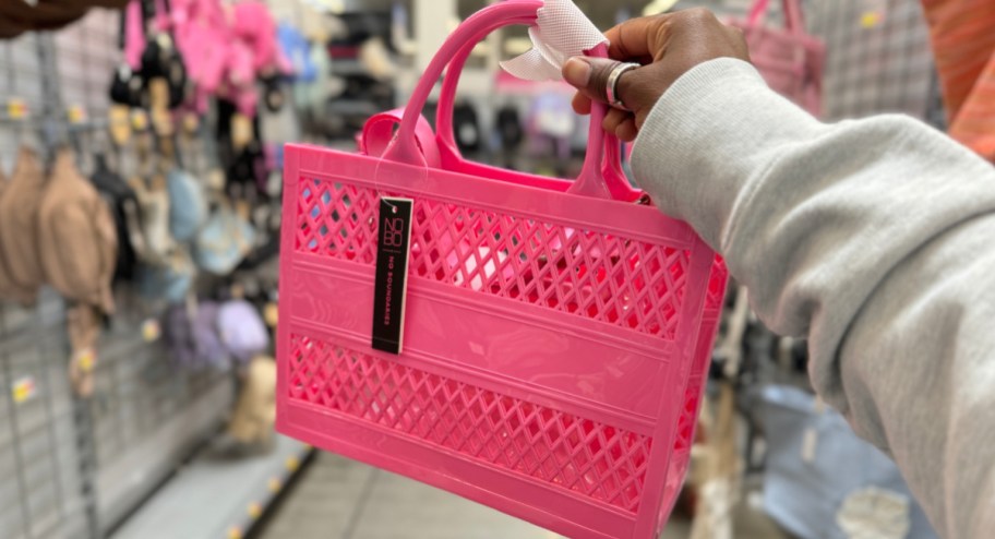 hand holding jelly Walmart purse at the store in pink