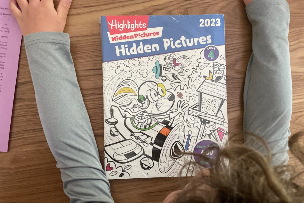 boy looking down at highlights hidden pictures book