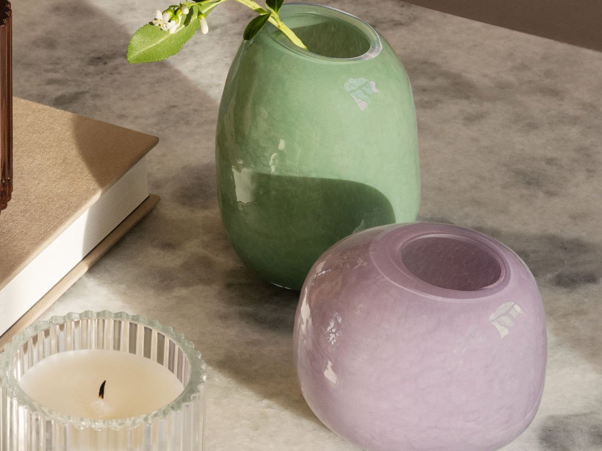 stoneware purple and green vases on counter next to candle
