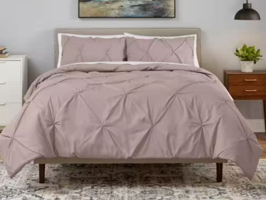 bed with dusty mauve pink ruche style comforter and shams