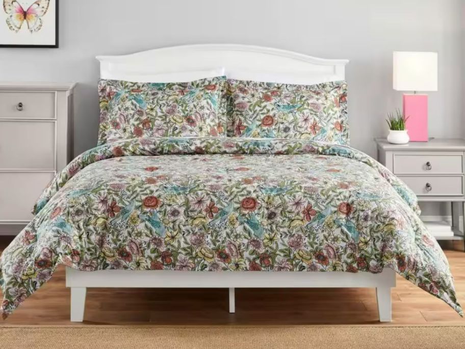 floral comforter and shams on a bed with white wood frame