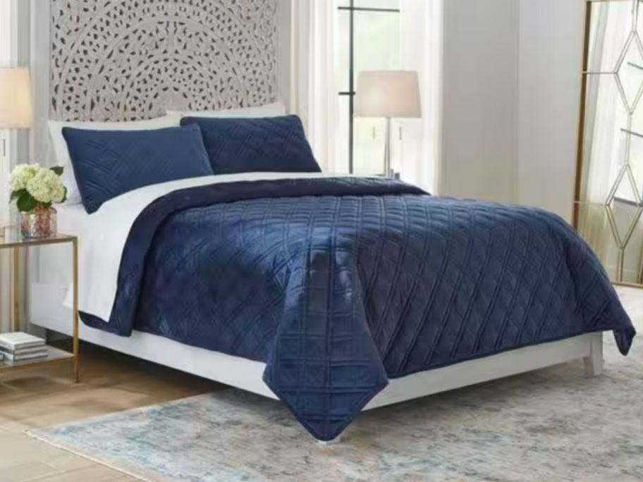 blue velvet comforter and sham set on a bed in a bedroom