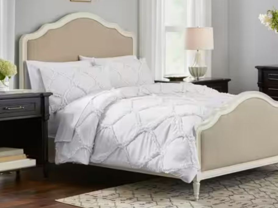 white ogee boho style comforter and sham set on a bed with a vintage style headboard