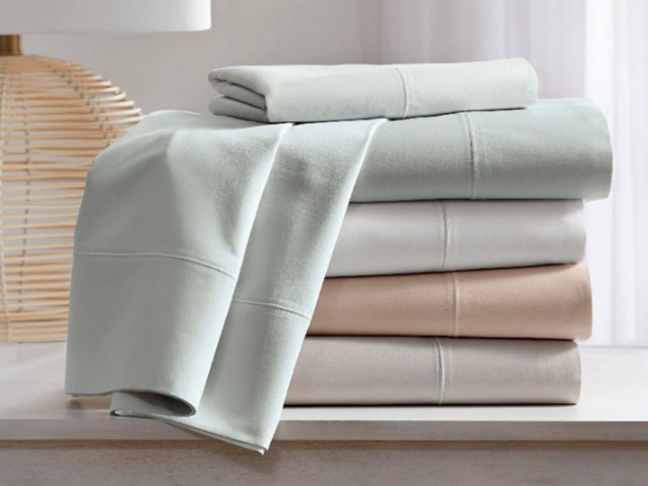 sheet sets in various colors stacked on a dresser