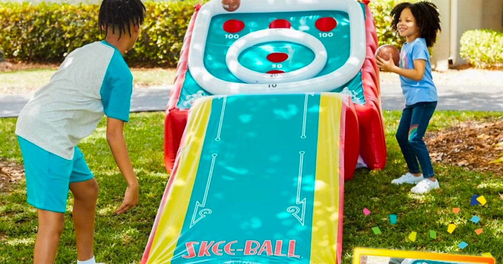 two children playing with inflatable skee ball game 