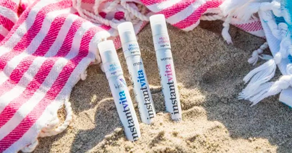three instantvita multivitamin sprays in sand at beach