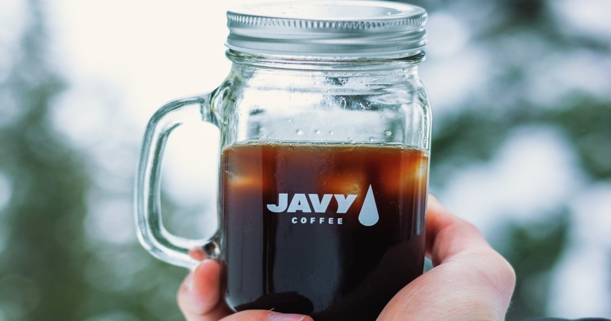 hand is holding javy cold brew in tumbler glass