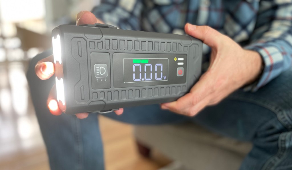 hand holding jump starter with flashlight turned on 
