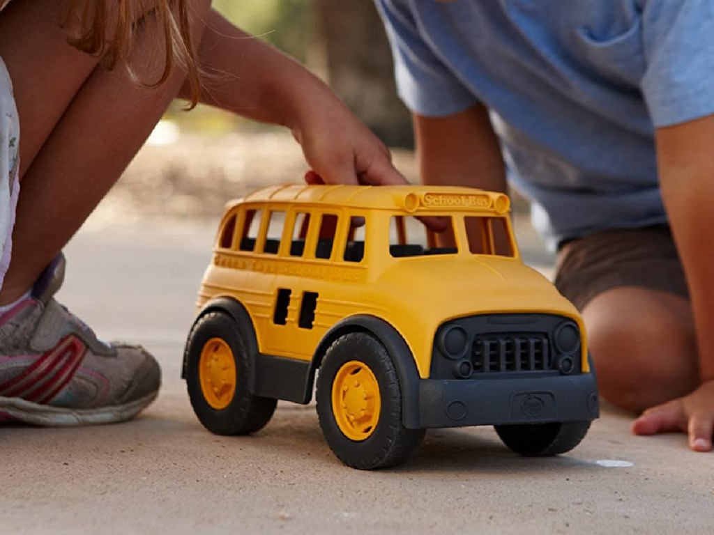 kids playing with Green Toys School Bus on the sidewalk