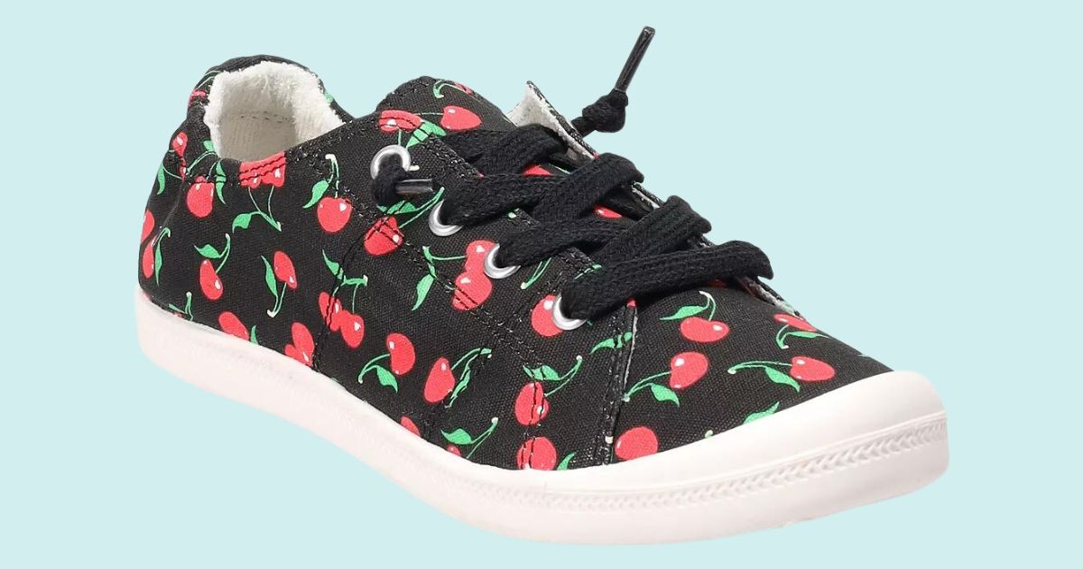 black and red sneakers with cherries all over them, black laces and white sole with blue background