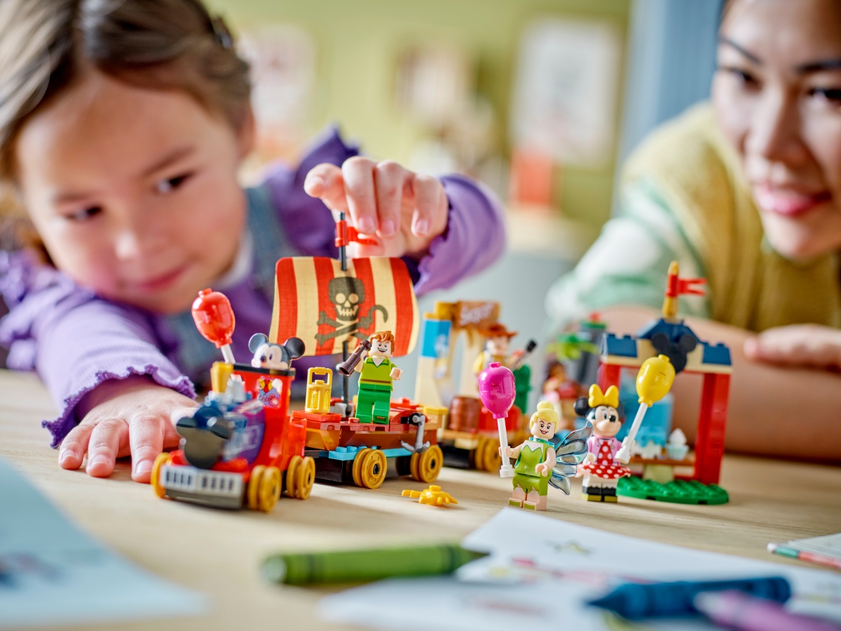 child building LEGO celebration train