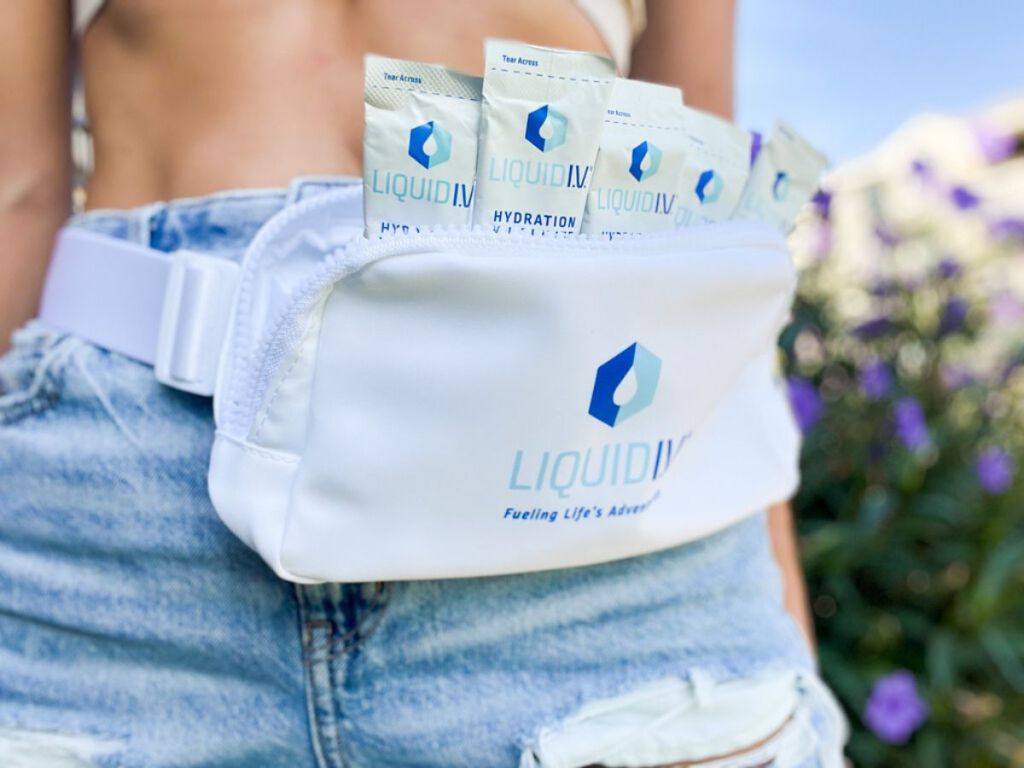 woman wearing Liquid IV belt bag filled with Liquid IV packets