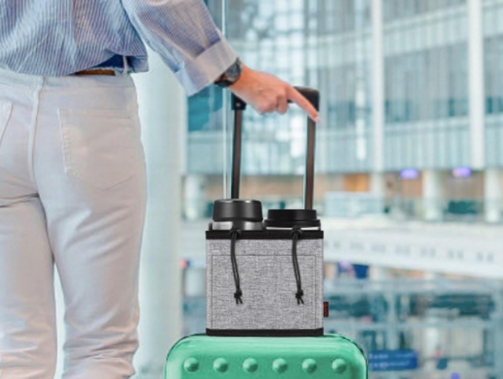 woman standing in airport with suitcase and luggage cup holder on top best travel products