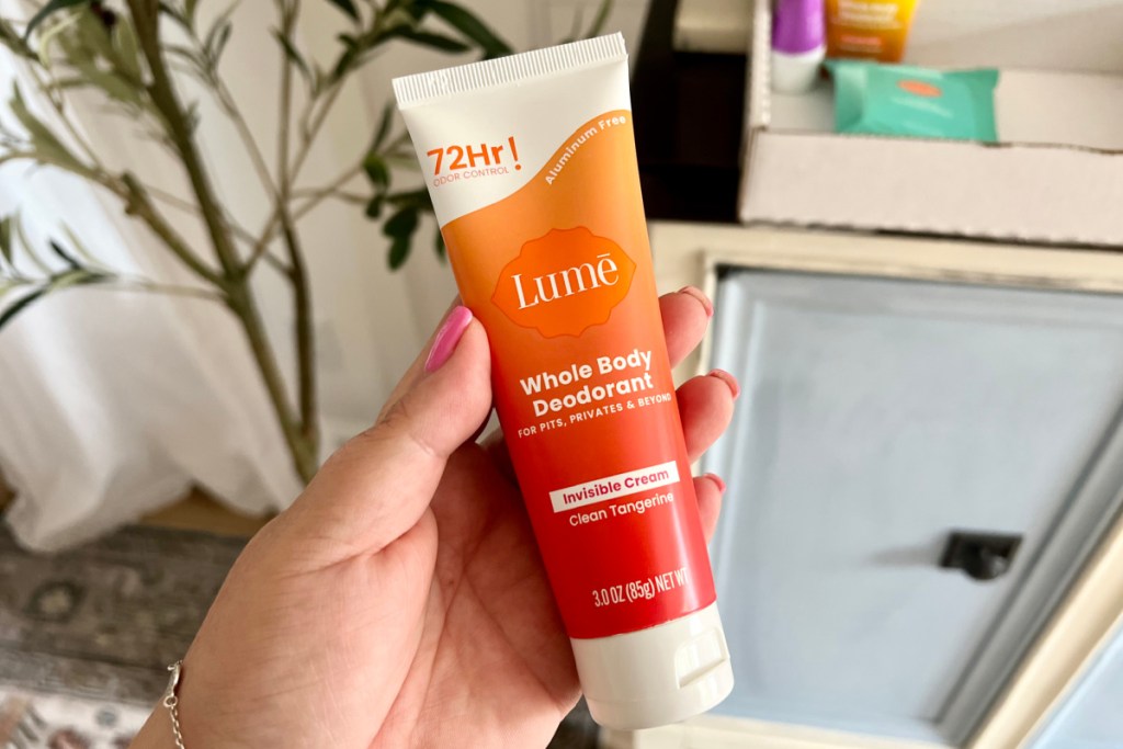 hand holding tube of whole body deodorant