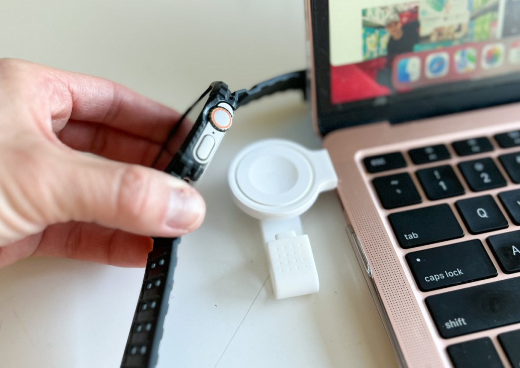 placing apple watch onto portable charger plugged into laptop