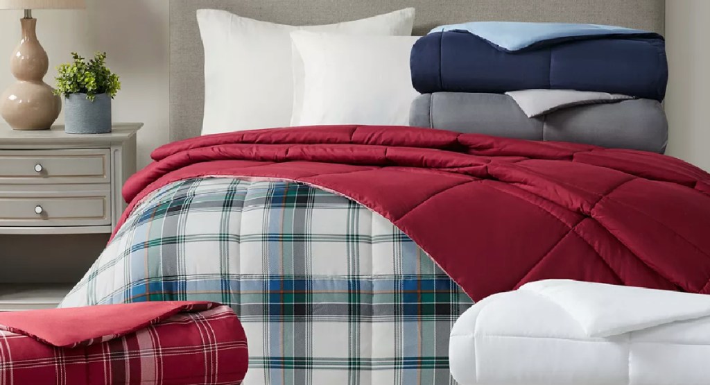multiple comforters on the bed and floor in different patters and colors