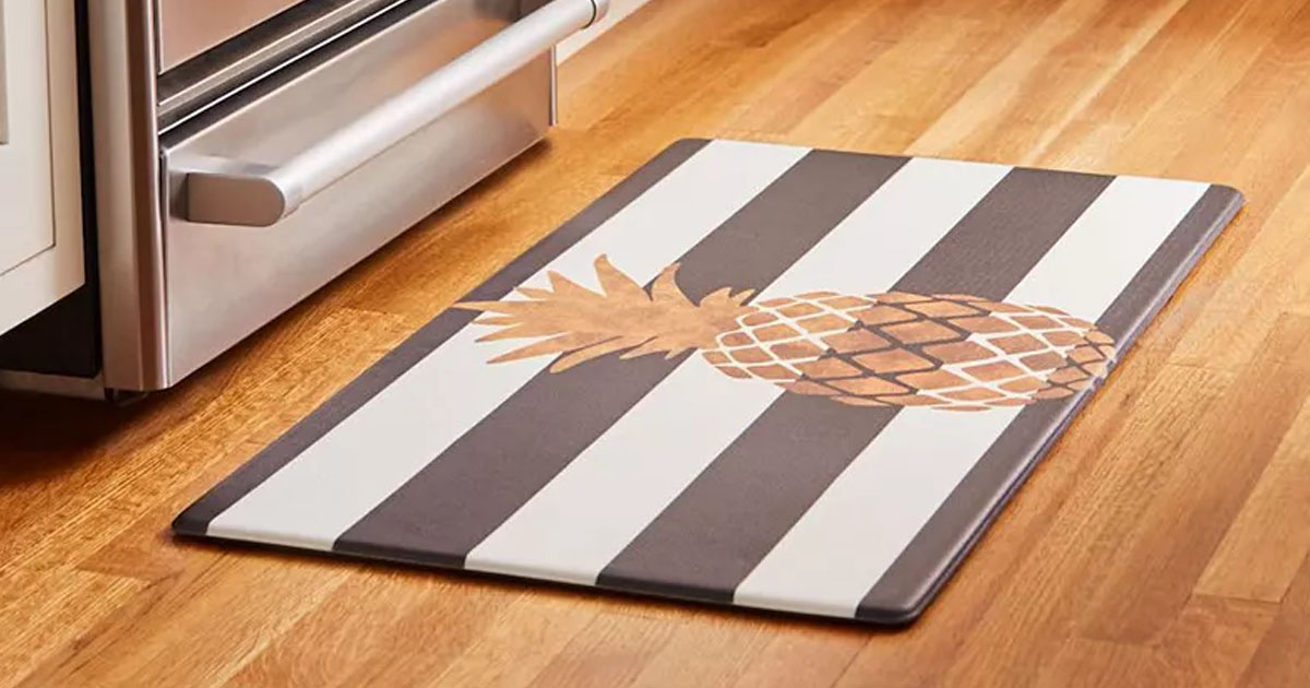 black and white striped ktichen mat with gold pineapple on wood floor 