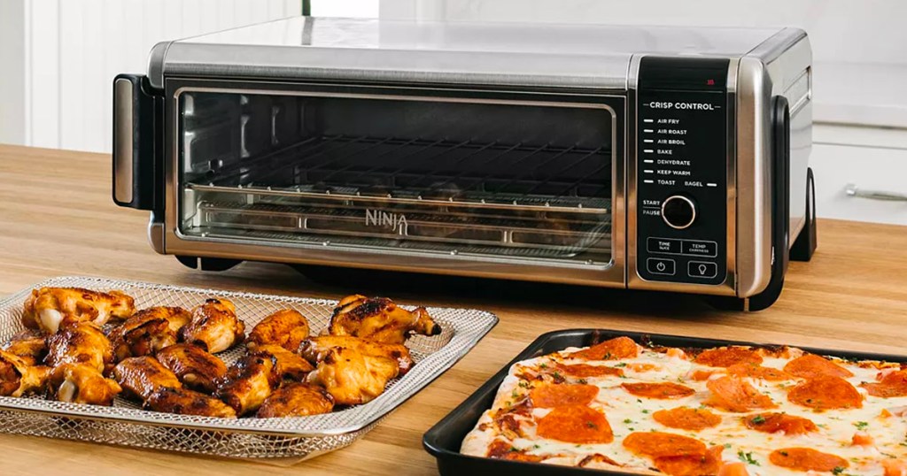 ninja food air fryer oven on counter with pizza tray and wings 
