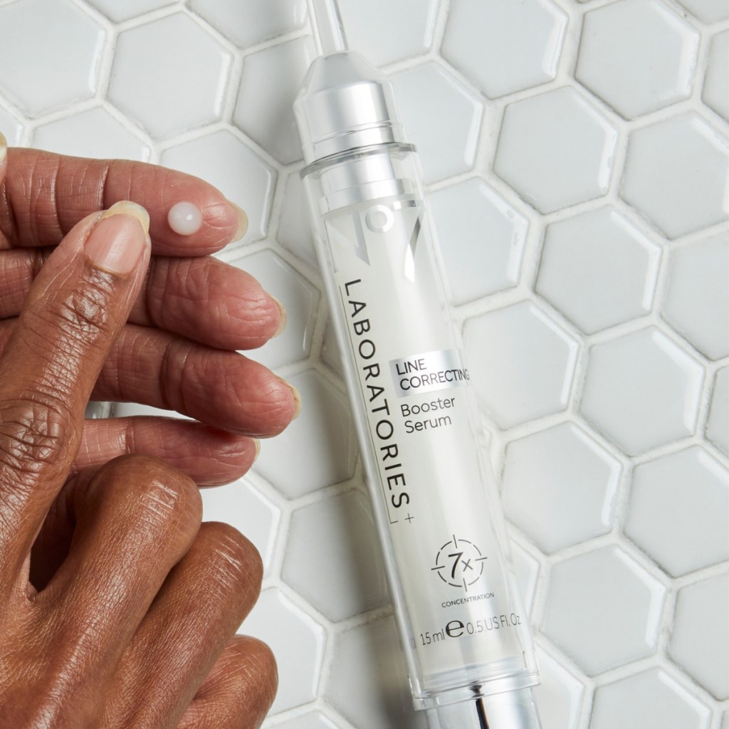 wrinkle serum next to hand on white tile