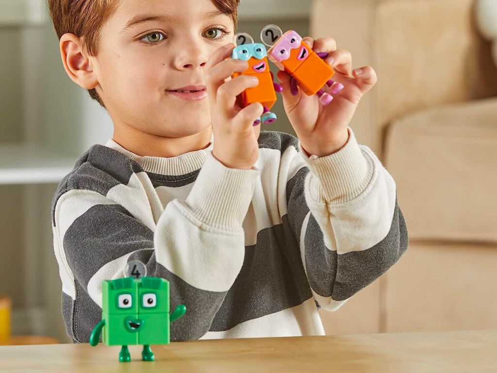 child playing with numberblocks figurines