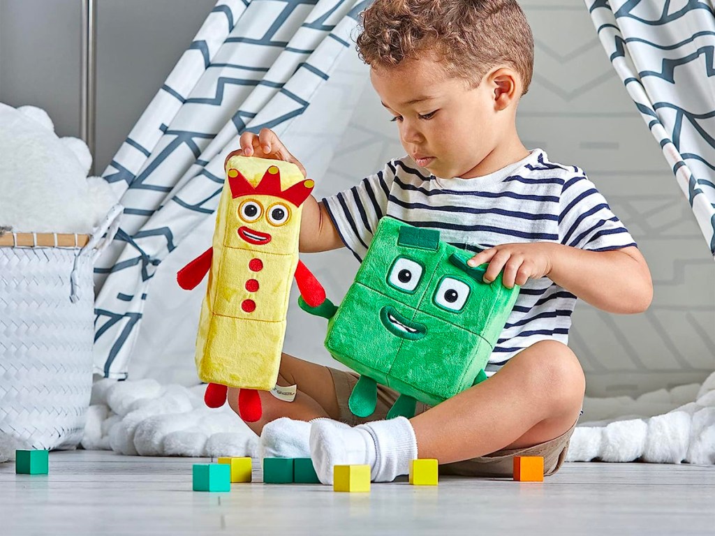 child playing with numberblocks plush toys and blocks