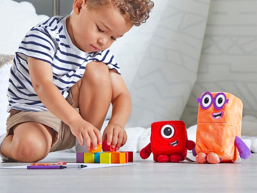 child playing with numberblocks plush toys and blocks