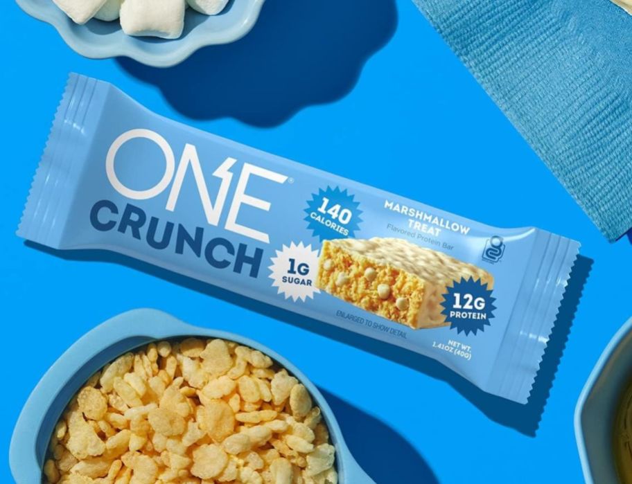 one protien crunch rice crispy treat protein bar shown with a bowl of rice cereal