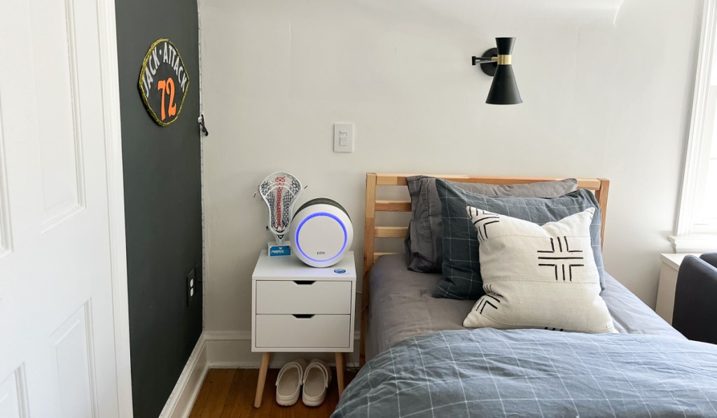 pure enrichment air purifier on a night table next to a bed
