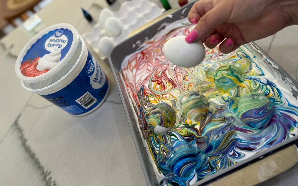 putting eggs in colored whipped cream