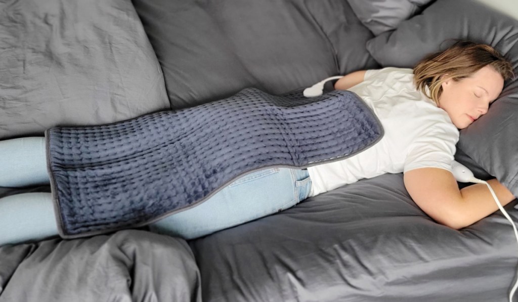 woman laying with heating pad on back