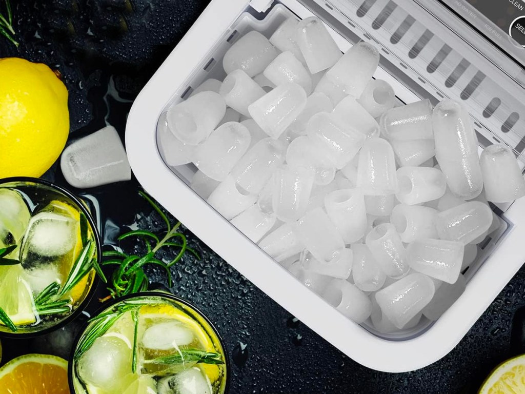 countertop ice maker open full of ice with lemons next to it